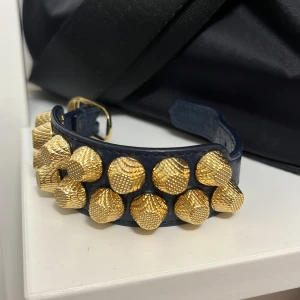 Balenciaga armband - säljer nu mitt armband från Balenciaga. Köptes från vestiaire collective. Svart läder med guldnitar. Pris kan diskuteras!