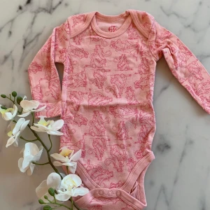 Ny långärmad body rosa 62-68 - Oanvänd och ej upptvättad men inga lappar kvar.  Ljusrosa body med gulliga tryck från Ice Age, strl 62/68. 