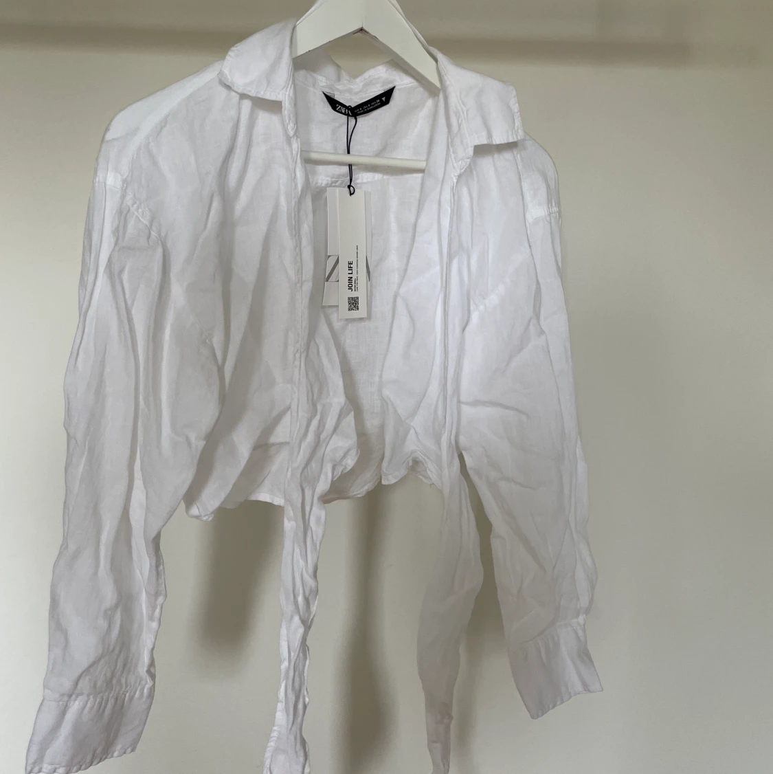 Vit linneblus som knyts i midjan