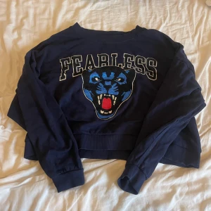 Hoodie med tryck  - Marinblå tröja från Ginatricot med ett coolt tigertryck i glitter. Glittret i munnen på tröjan har tyvärr gått bort med tiden(men syns knappast), annars är tröjan som ny då den är använd 1-2 gånger. Tröjan är liite croppad i modellen. 