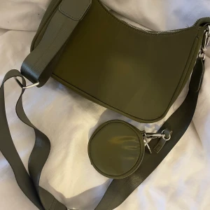 Väska - En fin miltär grön väska köpt på glitter för inte så länge sedan. Inte använd en endaste gång utan bara legat i garderob, så helt ny.  Kontakta vid intresse 66kr för spårbar frakt