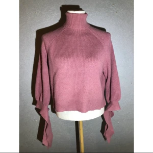 Polotröja - En stickad polotröja med fina detaljer vid handleden 