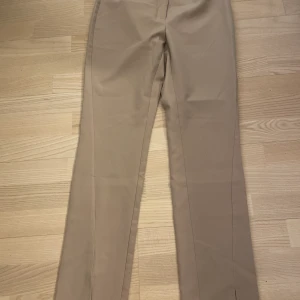 Kostymbyxor - Helt oanvända beiga kostymbyxor med slits i storlek 34 säljer för 70kr💓