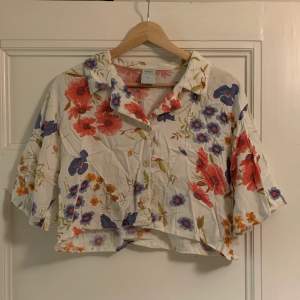 En croppad linneskjorta med blommor. Köpt på Popbouitique Gbg men märker är Canada. Storlek 40 men liten i storleken. 80kr + frakt (cirka 50kr)