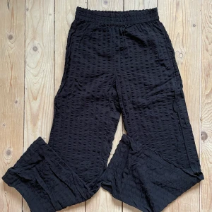 Svarta byxor Gina Tricot - Amanda byxor i bomull med struktur. Liknar linnebyxor i modellen men lite snyggare material. Endast använda ett par gånger hemma. Storlek XS.   Obs snabb affär pga flytt💚