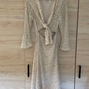 Adoore klänning - Riviera dress Lemon från Adoore. Använd endast en gång. Är i mkt fint skick, som ny. Vit bakgrund på klänningen med gula blommor.