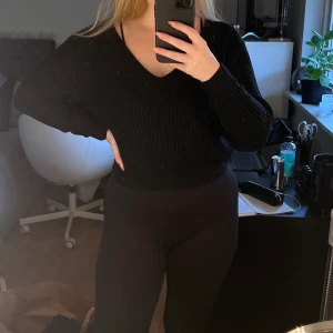 Svart stickad tröja - En svart stickad tröja med v-ringning från H&M i storlek S. Lite kortare i modellen, använd ett fåtal gånger