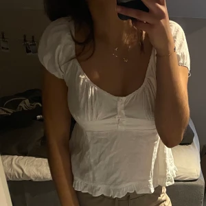 Vit topp-brandy melville - Så gullig topp från brandy melville!!! Använd ett fåtal gånger men är i jättebra skick🙏🏼den är onesize ungefär storlek S