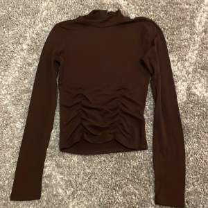 En långärmad brun tröja i storlek xs från Gina Tricot 