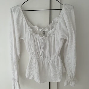 Topp, strl 34 - Vit topp från Nelly. Använd en gång. Frakt ingår ej i priset. 