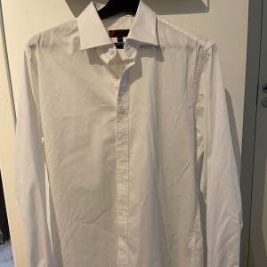 Skjorta ifrån Dressman, ej använd.Den är i slim fit. Och den sista bilden är hur knappen längst ner på skjortan ser ut.