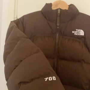 The North Face 1996 Retro Nuptse Brun - Extremt sällsynt jacka från The North Face i färgen brun.  Jackan går inte att få tag på i butik och är extremt svår att hitta online.  Den är i nyskick i storlek XS Dam. Jackan ligger uppe på budgivning på Tradera.
