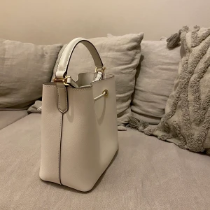 Väska Michael kors ny - Säljer denna helt nya Michael Kors väska i VIT med guldiga detaljer!!!🥰 Helt oanvänd, prislapp sitter kvar, kvitto, påse, reglerbart band, inslagning och care card tillkommer. Både Axel och handväska! Ca 30x40cm! Nypris ligger på ca 5000kr🌸 Frakt =66kr