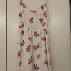Vitblommig klänning - Inköpt på h&m för många många år sedan, använd under en sommar annars har den bara legat i garderoben. 