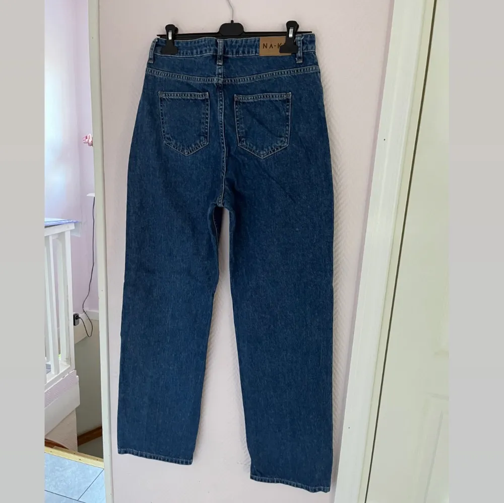 Mörkblå högmidjade vida jeans från NA-KD i storlek 38, använda ca 5 ggr. Säljer då jag ändrat stil. Inga avvikelser på de. Köpta för 499kr, säljer för 300kr då de knappt är använda. Är perfekta på mig som är 170cm och brukar ha 38/M.. Jeans & Byxor.