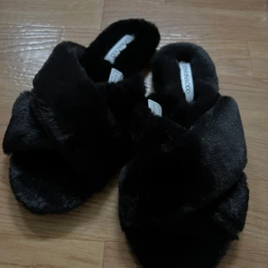 Svarta tofflor  - Svarta mjuka tofflor med korsande band, super mjuka och helt oanvända! Skickas i orginalförpackning. 😇❤️‍🔥 Nypris: 249kr