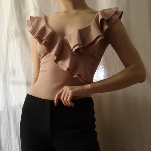 NLY ONE body ruffled top - Storlek XS men den är stretchig. Skönt plagg i bra skick. Färgen är gammelrosa och bodyn kan knäppas upp nerifrån.