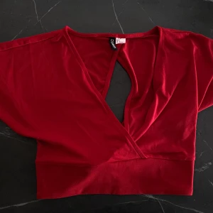 Röd topp med knytning bak från Divided HM, strl. S - Röd t-shorts/topp med justerbar rosettknytning i ryggen, använd 1 gång så är i nyskick. Från Divided HM i storlek S, men passar även XS. Köparen står för frakt🌻