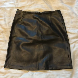 Skinnkjol - En svart skinnkjol från Bikbok i storlek xs men passar mig med s, väldigt skön då de inte är läder inuti utan ett mjukare material. Den har även dragkedja där bak. 