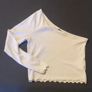 Vit one shoulder topp - En snygg one shoulder topp i ribbat material och långarmad. Perfekt till vardags såväl som utekvällar.  (Slimfit) 