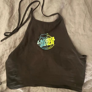 halterneck top - grå halterneck top med tryck, från HM. använd några gånger men superfint skick.  hör gärna av dig vid intresse:) 