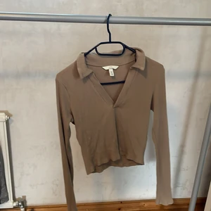 Hm - Långärmad top/tröja.storlek small. Färg;beige/brun I använt men gott skick. Hund finns i hemmet.