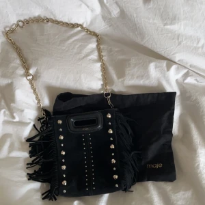 Maje väska  - Säljer min lilla maje väska som är svart med nitar. Köpt förra sommaren i butiken i Stockholm, i väldigt bra skick och inte använd många gånger!! Man får med både kjedjan och det andra svarta bandet👌🏼❤️