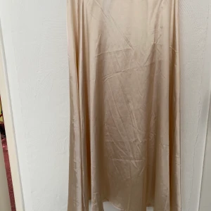 Satinkjol  - En champagnefärgad satinkjol som är relativt lång, den är sparsamt använd. Storleken är S🥰