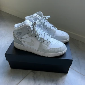 Nike Air Jordan 1 Mid Grey Camo - Snygga Air Jordan 1 Mid Grey Camo i bra skick. Har använts fåtal gånger och med creasing-skydd. Dessa går för ca 2500-3000 på StockX. Kvitto, orginalbox och klistermärke finns kvar. Skickas dubbelboxat och spårbart