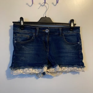 Regular / low rise Jean shorts  - Jean shorts från Next i storlek 38 med fin spetz detalj. Lite stretch. Använda enbart ett få tal gånger. (Naturligt ljus på första 2 bilderna, lampa på sista). Alla ”distress” märkena är del av designen & köptes så.  Köparen står för eventuell frakt <3