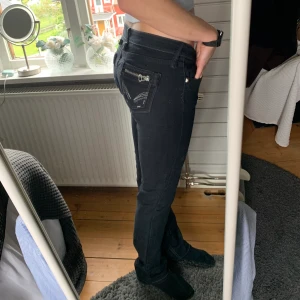 Lågmidjade jeans - Lågmidjadw svarta jeans köpta second hand i storlek 29 motsvarande 36/38☺️ Silverdetaljerna på bakfickorna och de gråa sömmarna gör allt!🤍