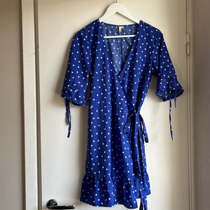 Omlottklänning Stl:36 - En blå klänning med vita prickar från Nelly! Knyts ihop till en klänning! 