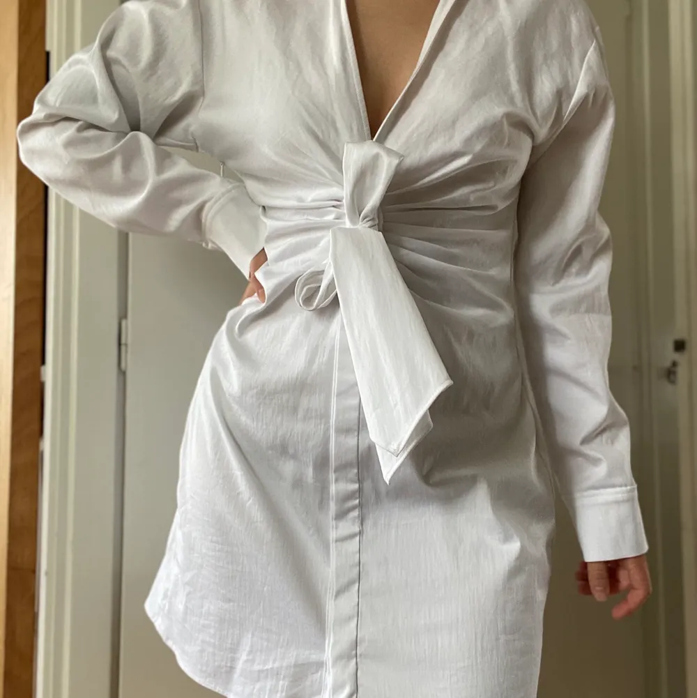 Helt ny vit skjortklänning med knytdetalj i midjan. Inköpt på Zara för 400kr men passade inte mig riktigt som jag ville. Säljer nu för 200kr + frakt. ✨. Klänningar.