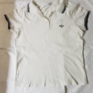 Piketröja av danska Sand - Vit Tenniströja från danska märket Sand. Mycket fint skick. Nypris i butike ca 1000 kr. Jag säljer för 150 kr