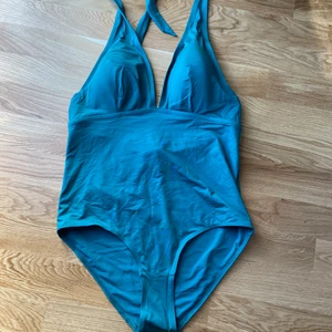 Oanvänd baddräkt stl. 44 - Helt oanvänd baddräkt från H&M med låg rygg och halter band! Färgen är mörkare k verkligheten!