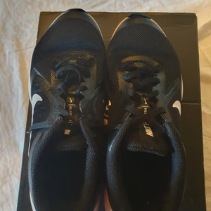 Nike snickers Downshifter - Har inte haft på mig den mycket.Inga hål den har inga skador.De blev för små för mig så jag säljer de men de är väldigt fina och passar för att ha på sig när man är ute eller idrott och träning. De kostade ungefär 600 kr