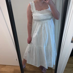 Vit klänning från Vero Moda strl L - Superfin klänning från Vero Moda storlek L. Aldrig använd bara testad! Den har en smock över hela bröstet och rygg. Klänningen går ner till mitten på mina vader ungefär, jag är 169cm lång. Denna är ju en kandidat för studentklänning! 250kr inkl.Frakt