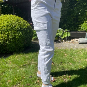 Vita cargobyxor - Andra bilden är lånad. Byxorna är använda bara ett fåtal gånger och är i nyskick. Tjockt bra material som inte är genomskinligt. Jag är 181.5 cm som referens. Man kan välja själv om man vill bära dem high eller low waisted. Nypris ca 600kr