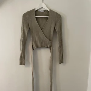 Omlott topp - Omlott topp från Zara i grönt ribbat material. Storlek S. Skriv för bilder med toppen på, för bättre bild av passform osv. Nypris 400kr, säljer för 150kr + frakt (frakten kan variera utöver skrivet pris). 