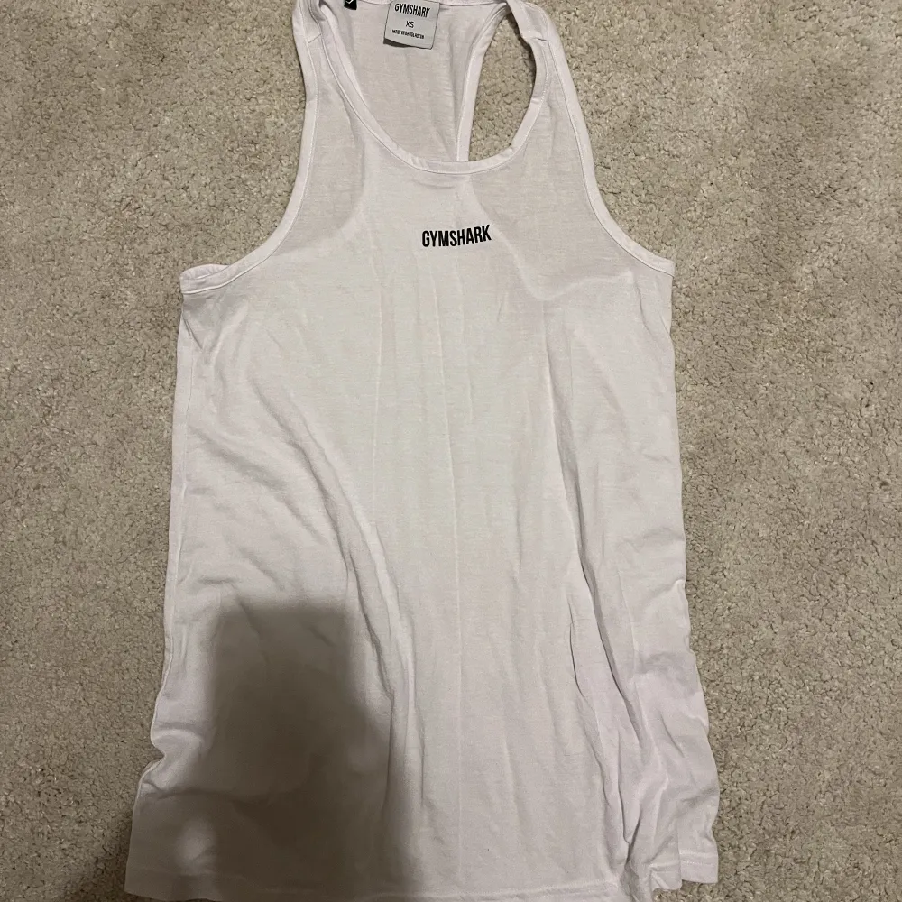 Ett vitt linne från gymshark i strl XS som ränotroligt luftigt och skönt! Lite ”genomskinligt” och slappt i modellen 🥰. T-shirts.
