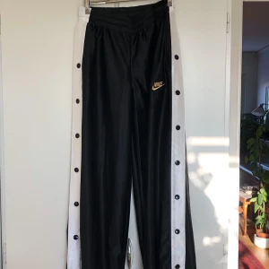 Nike trackpants - Supersnygga trackpants från Nike! Byxorna har fickor och knappar längs benen som går att öppna. Obetydligt använda, som nya. Inköpspris ca 600kr