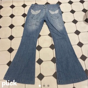 Lågmidjade flare jeans - Jätte snygga och unika 2000s bootcut jeans, coola fickor och snyggt material. Älskar dom super mycket men är alldeles för små för mig. Köpt från Plick och bilderna är från förra ägaren.Midjemått tvärs över 37 cm, innerbenslängd 78 cm