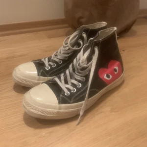 Converse All-Star CDG - Ett par svarta Converse All-Star i samarbete med Comme Des Garcons Play, därav hjärtat. Gott skick, inte använda väldigt sparsamt Tyvärr ingen medföljande skolåda då den är slängd sedan en tid tillbaka.