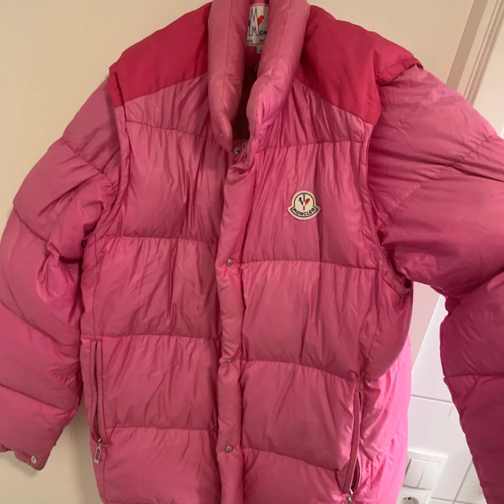 En vintage rosa moncler jacka där man kan ta av och sätta på armarna genom blixtlås, så man kan både anvönde den som jacka och väst . Jackor.