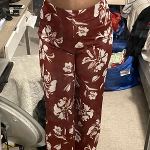 Byxor - Vinröda byxor med blommönster på från Shein. Känns lite som att det är simmaterial. Aldrig använda. Storlek M.
