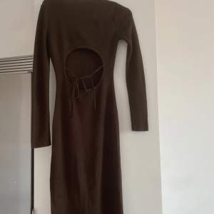 brun klänning från Asos inköpt för 599kr går till knäna med slits på vänstersidan supersnygg och väldigt lite använd!  öppen rygg med snörning