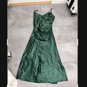 Grön klänning som är använd Max 1 gång har en dragkedja på kanten.  Längden är till underkänna 