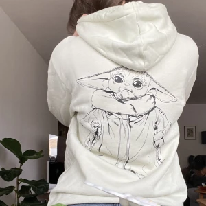 Baby Yoda hoodie - Härligt mintfärgad hoodie med baby Yoda på!! Så himla söt.  Den har använts ganska mycket och har därför en del missfärgning vid ex. ärmen, därför så lågt pris. Materialet på insidan är super mjukt!  Stl s men passar definitivt större
