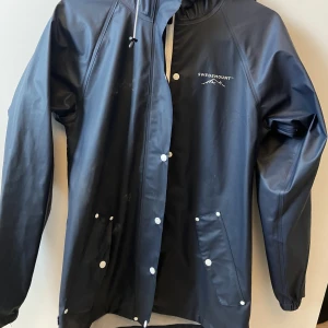 Regnjacka stl 34 - Klassisk regnjacka från swedemount. Bara ett efternamn som är överstruket. Knappt använd och är i fint skick. 