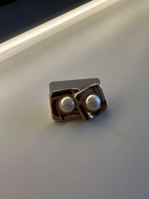 Örhängen  - Guldiga örhängen med en vit pärla i mitten. Aldrig använda. Köparen står för frakt🫶🏽 Kolla gärna in min profil då jag säljer massor med andra örhängen💕